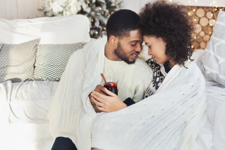 Couple relaxing with glass of warm wine on winter evening
